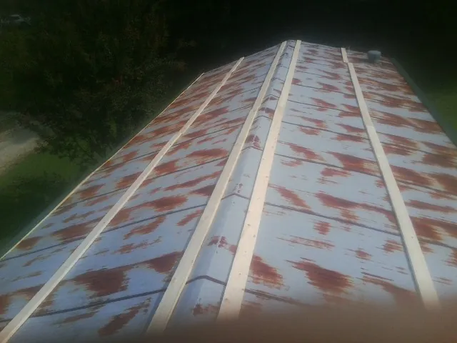 Rusted metal roof panels with new wood purlins before replacement — Storm Damage Roof Repair in Siletz by Roofing Brothers