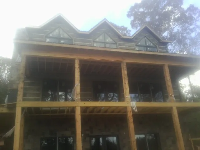 Dormers and porch framing on a large log home under construction — Roof Coating work by our crew in Siletz